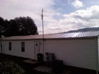 New metal roof on a single wide mobile home with a TV antenna in King City